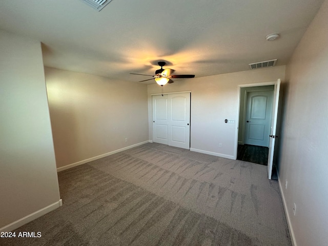 unfurnished bedroom featuring ceiling fan, a closet, and carpet floors