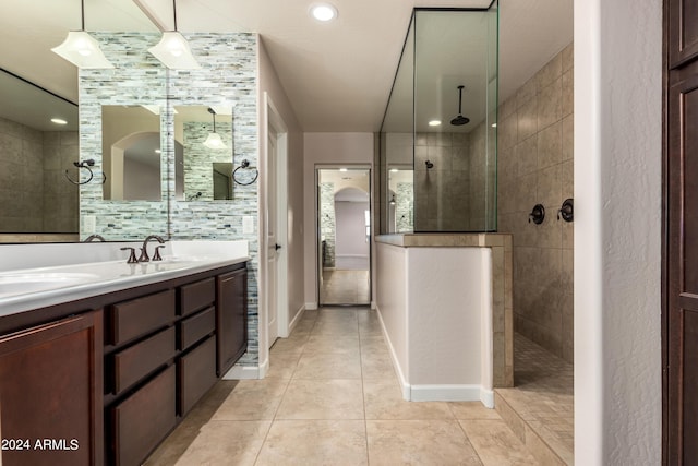 full bathroom featuring baseboards, walk in shower, double vanity, tile patterned floors, and a sink