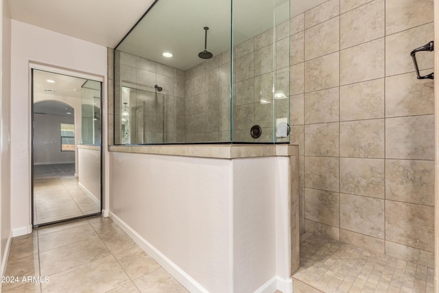 bathroom with tile patterned floors, baseboards, and walk in shower