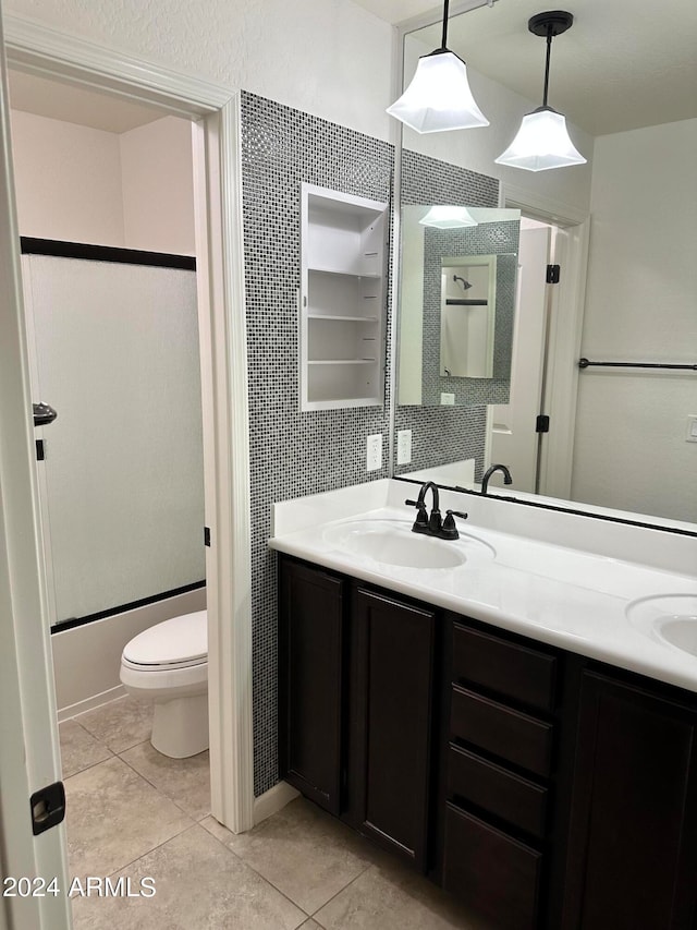 bathroom with toilet, vanity, and tile patterned floors