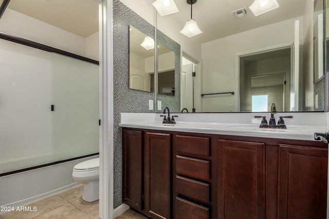 full bath with tile patterned floors, enclosed tub / shower combo, visible vents, and a sink