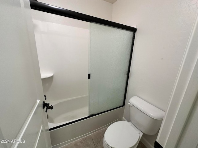 bathroom featuring bath / shower combo with glass door and toilet