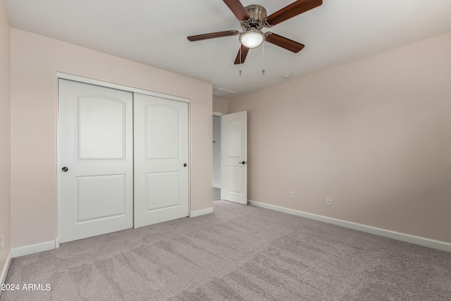 unfurnished bedroom featuring visible vents, a closet, carpet flooring, baseboards, and ceiling fan