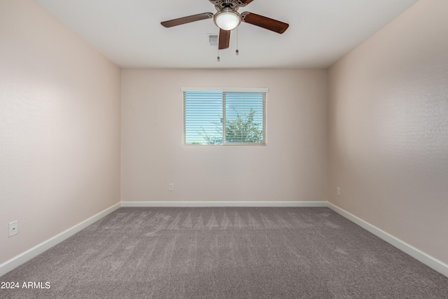 carpeted empty room with a ceiling fan and baseboards