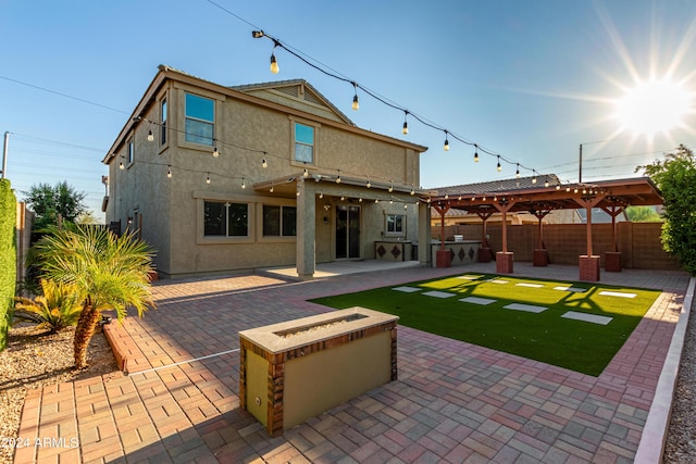 back of house featuring exterior kitchen, stucco siding, a fenced backyard, and a patio area