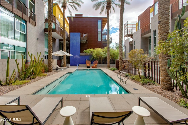 community pool with fence and a patio area