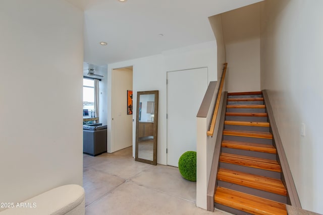 stairs with concrete flooring and recessed lighting