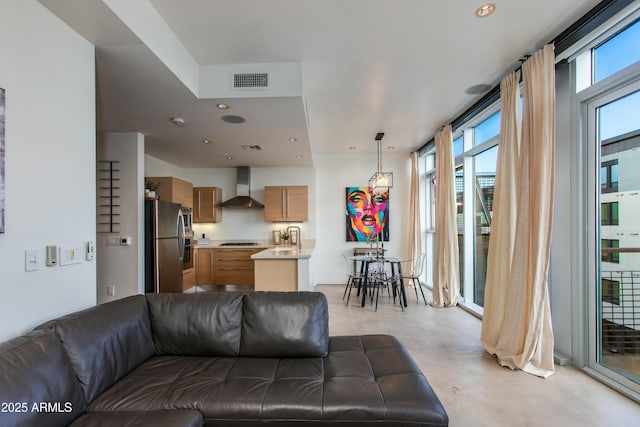 living room featuring healthy amount of natural light, finished concrete floors, and recessed lighting