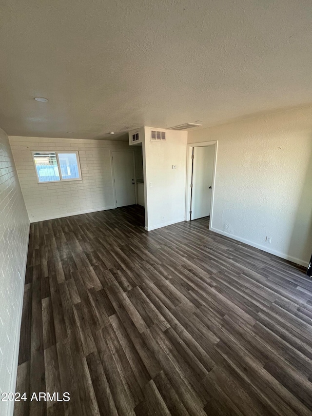 empty room featuring dark wood-type flooring and a textured ceiling