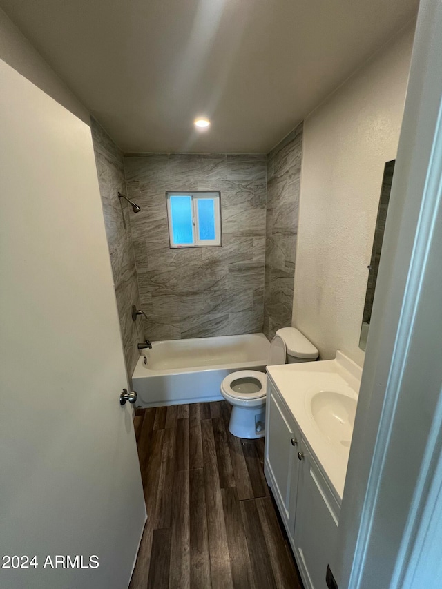 full bathroom with vanity, toilet, wood-type flooring, and tiled shower / bath