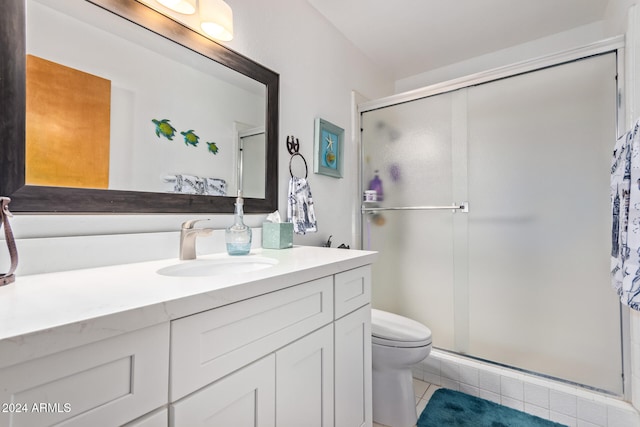 bathroom with tile patterned floors, vanity, toilet, and a shower with door