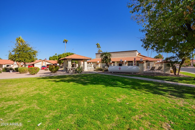 view of front of house with a gazebo and a front lawn