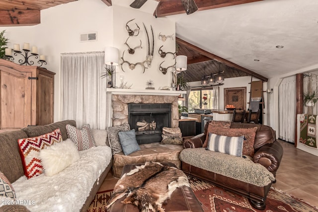 tiled living room featuring lofted ceiling with beams and a stone fireplace