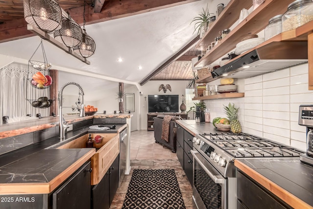 kitchen featuring backsplash, stainless steel gas range, lofted ceiling, and tile countertops