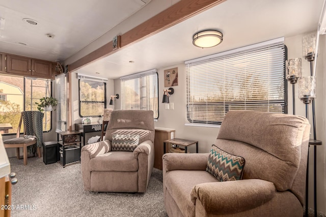 living area with beam ceiling and light carpet