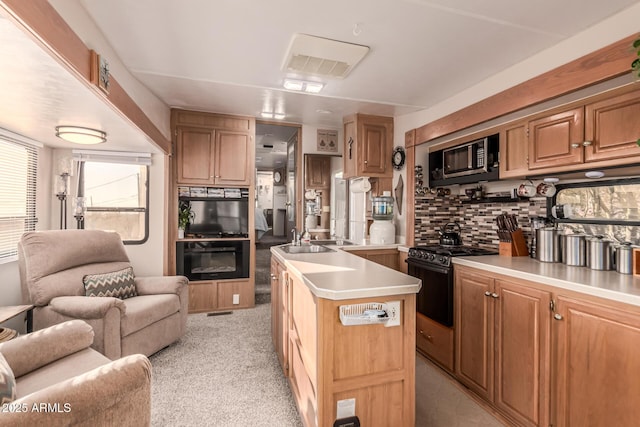 kitchen with light carpet, decorative backsplash, a center island, black range with gas cooktop, and sink