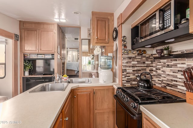 kitchen with decorative backsplash, sink, and black range with gas cooktop