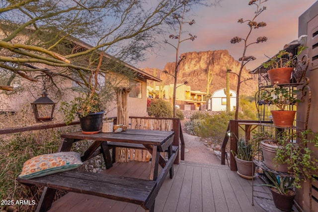 deck at dusk featuring a mountain view