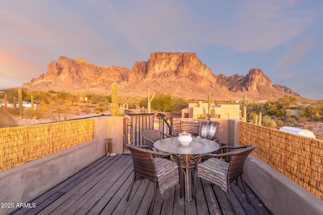 deck at dusk featuring a mountain view