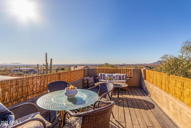 wooden deck with an outdoor living space and a mountain view