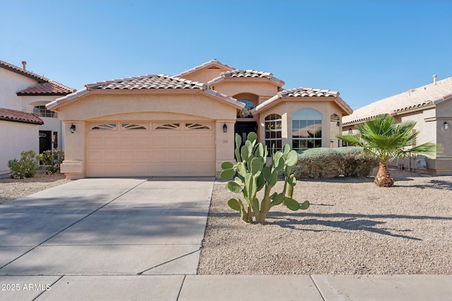mediterranean / spanish-style house featuring an attached garage, driveway, a tile roof, and stucco siding