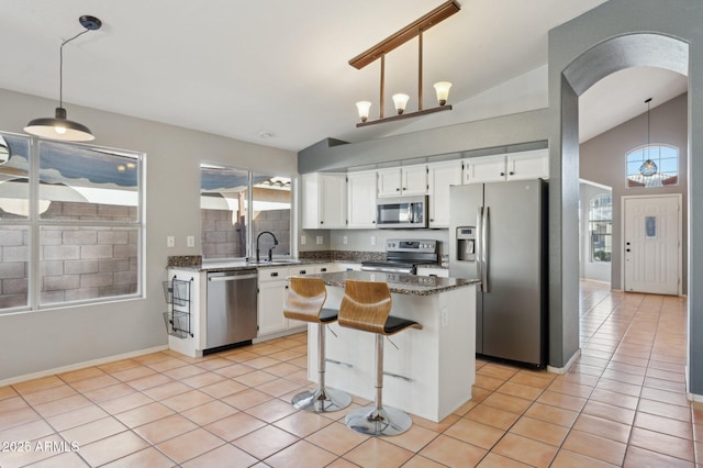 kitchen featuring a kitchen island, white cabinets, appliances with stainless steel finishes, and a wealth of natural light