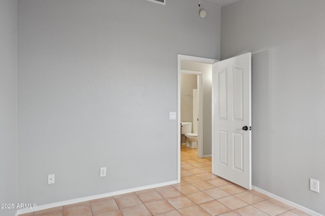 unfurnished room featuring baseboards and light tile patterned floors