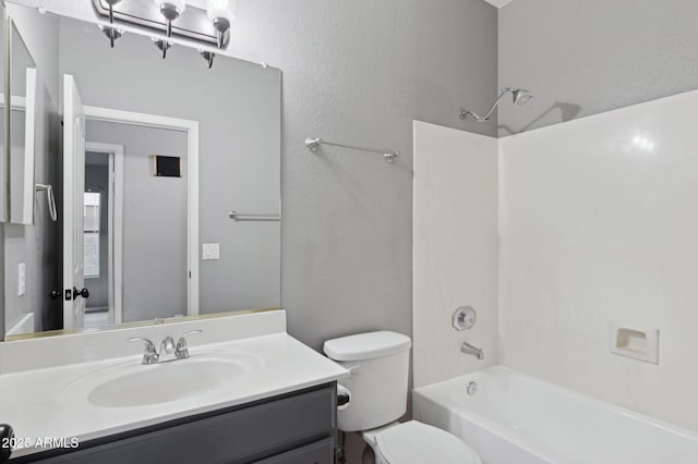 bathroom with vanity, washtub / shower combination, and toilet