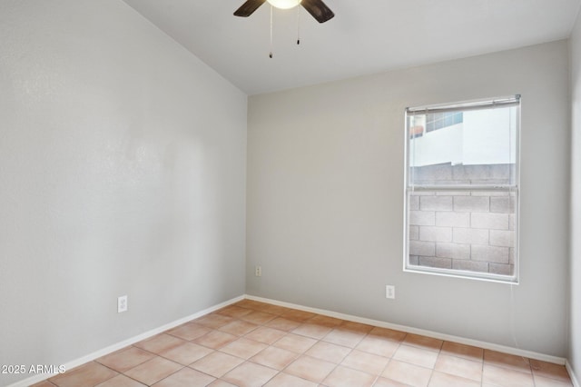 spare room featuring a ceiling fan, baseboards, and light tile patterned floors