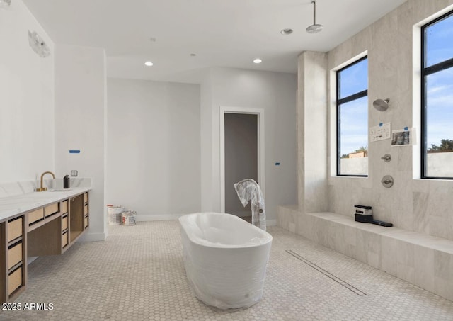 bathroom featuring plenty of natural light, recessed lighting, and a tile shower