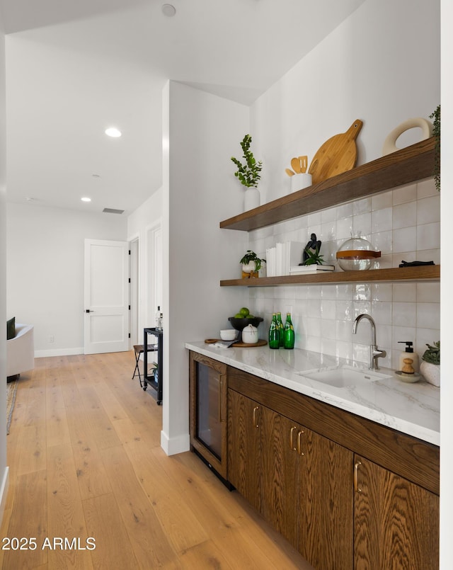 10220 N 66th St, Paradise Valley, AZ 85253 - bar featuring baseboards, light wood-style flooring, decorative backsplash, and a sink