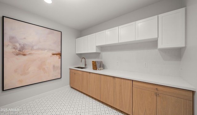 10220 N 66th St, Paradise Valley, AZ 85253 - kitchen with baseboards, white cabinetry, light countertops, and a sink