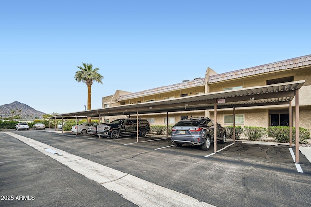 covered parking lot featuring a mountain view