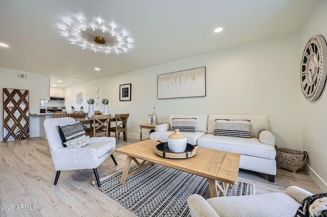 living area featuring visible vents, baseboards, an inviting chandelier, light wood-style flooring, and recessed lighting