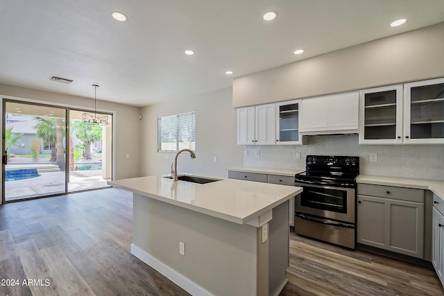 kitchen featuring a sink, visible vents, stainless steel electric range oven, tasteful backsplash, and custom range hood