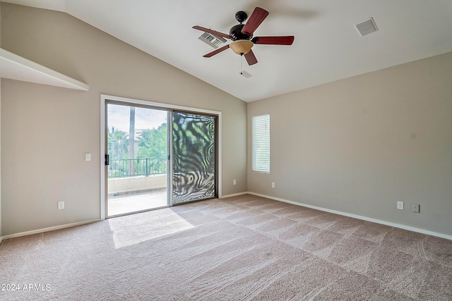 carpeted empty room featuring ceiling fan, vaulted ceiling, and a wealth of natural light