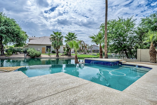 view of swimming pool with a pool with connected hot tub, a patio, and fence