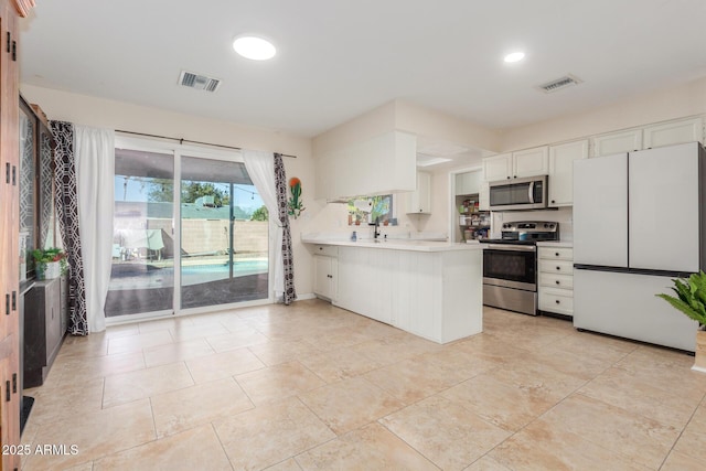 kitchen with white cabinetry, sink, light tile patterned floors, kitchen peninsula, and stainless steel appliances