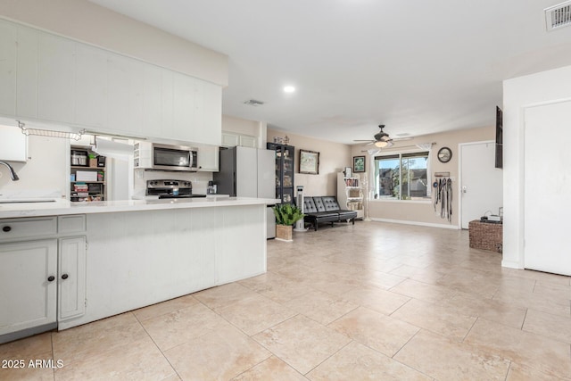 kitchen featuring sink, white cabinetry, appliances with stainless steel finishes, kitchen peninsula, and ceiling fan