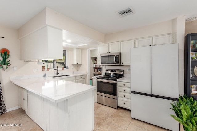 kitchen with white cabinetry, sink, light tile patterned floors, kitchen peninsula, and stainless steel appliances