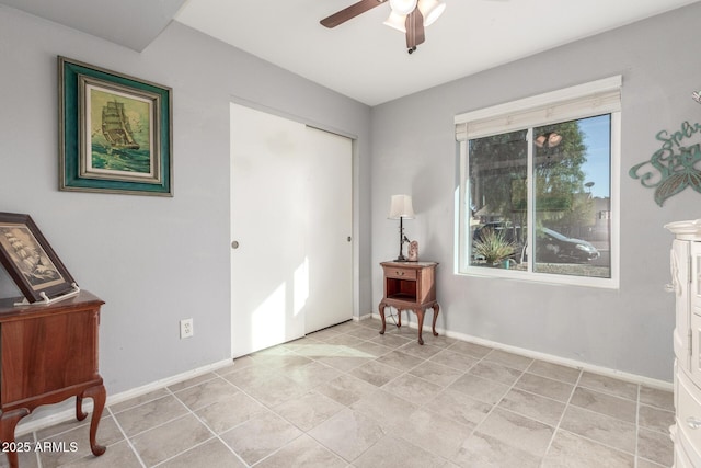 sitting room featuring light tile patterned flooring and ceiling fan