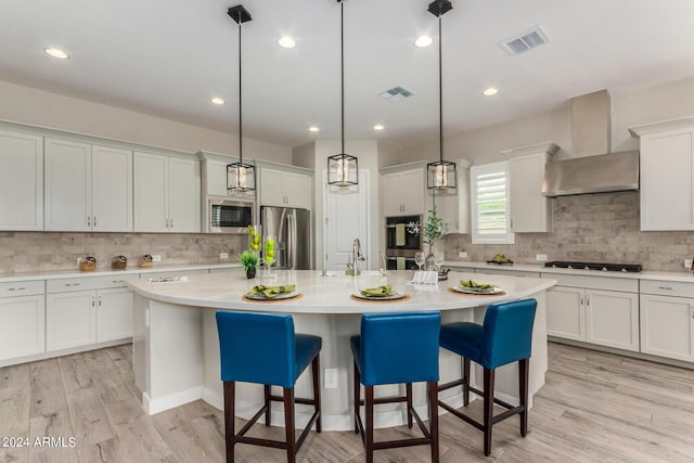 1557 E Flower St, Gilbert, AZ 85298 - kitchen with wall chimney range hood, visible vents, stainless steel appliances, and light countertops