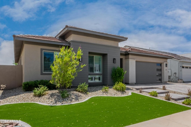 1557 E Flower St, Gilbert, AZ 85298 - prairie-style home featuring concrete driveway, an attached garage, and stucco siding