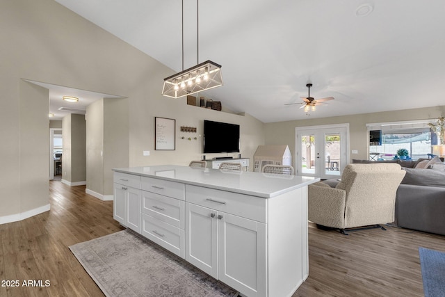 kitchen with hanging light fixtures, french doors, white cabinets, and light wood-type flooring