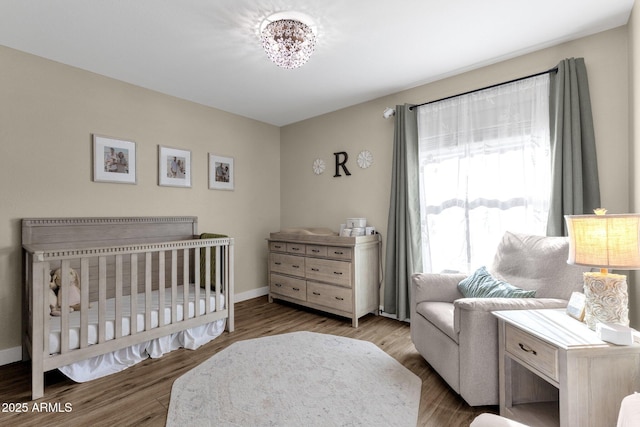 bedroom with hardwood / wood-style flooring and a nursery area