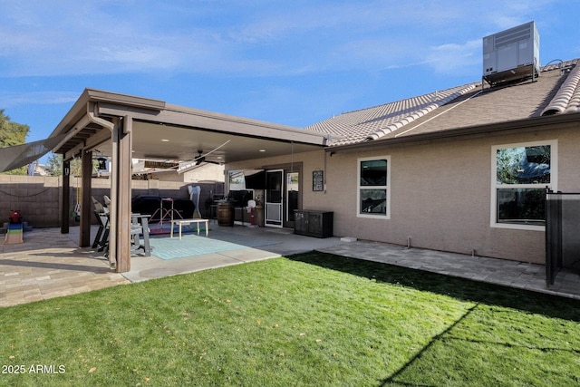 rear view of property featuring a patio area, central AC unit, ceiling fan, and a lawn