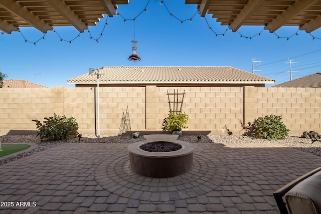 view of patio featuring a fire pit and fence