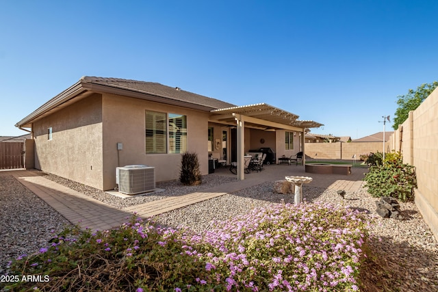 rear view of property with ceiling fan, a patio, cooling unit, a fenced backyard, and stucco siding