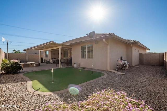 rear view of property featuring stucco siding, a fenced backyard, and a patio