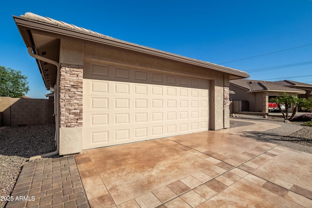 garage with driveway and fence